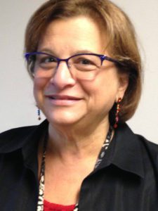 A woman wearing glasses and a red shirt.