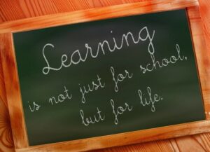 Learning is not just for school written on wooden slate
