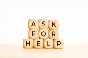 Wooden blocks spelling "ask for help"